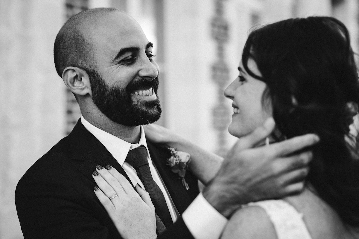 A joyful black and white portrait showing genuine laughter between newlyweds.