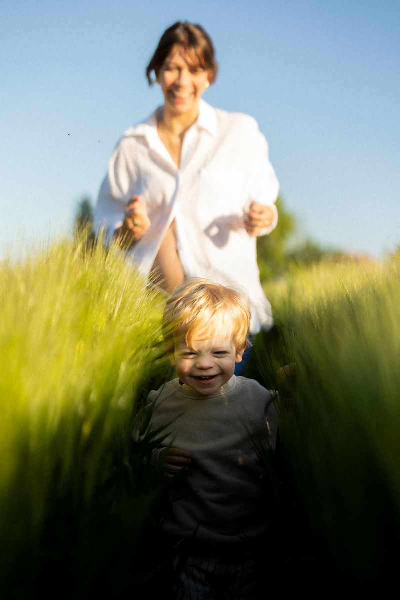 Candid moment in golden wheat field with bright sunlight and blue sky.