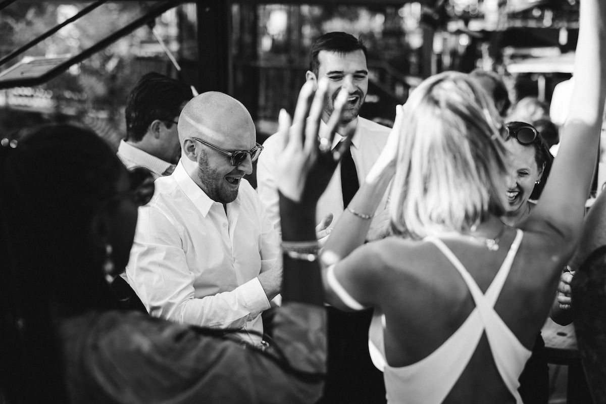 Black and white candid celebration moment at wedding reception.
