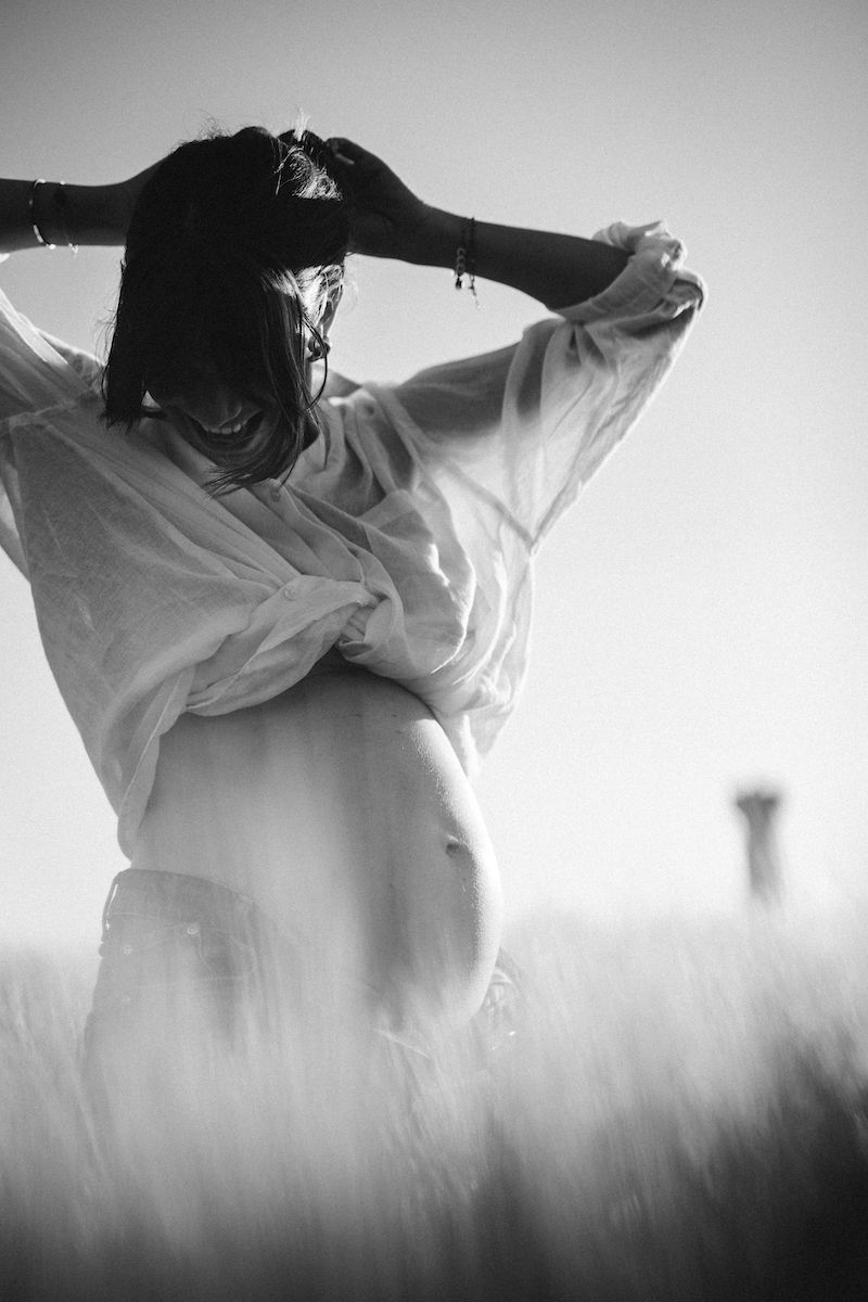Artistic silhouette of figure in white shirt against misty sky.