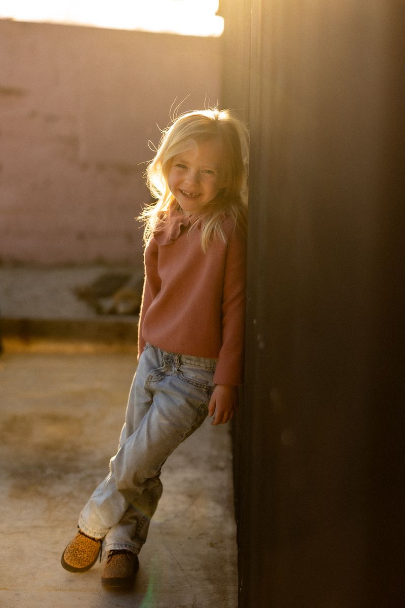 A series of sepia-toned images showing playful movement against a warm sunlit background.