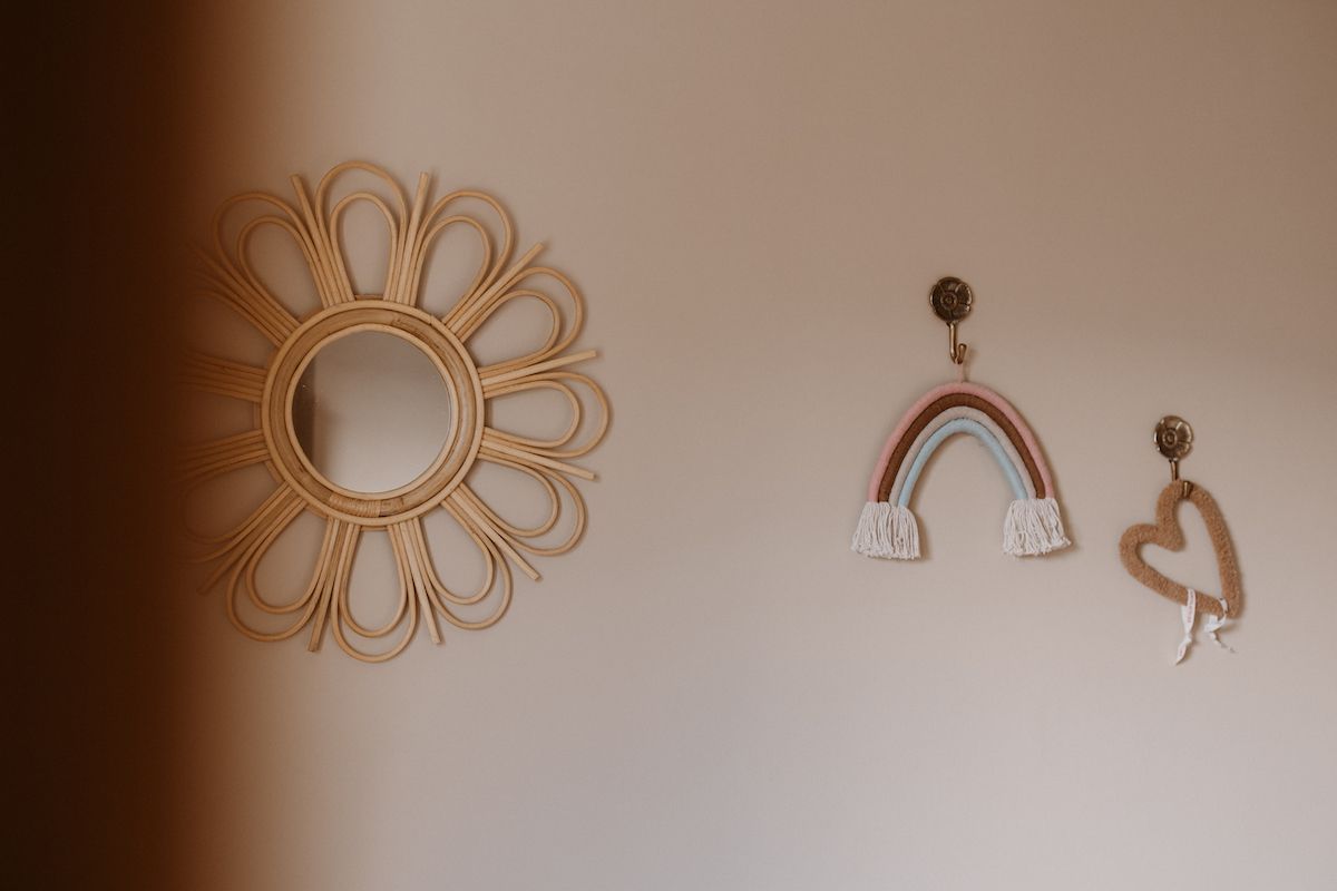 Decorative wall art featuring sun mirror and abstract rainbow designs.