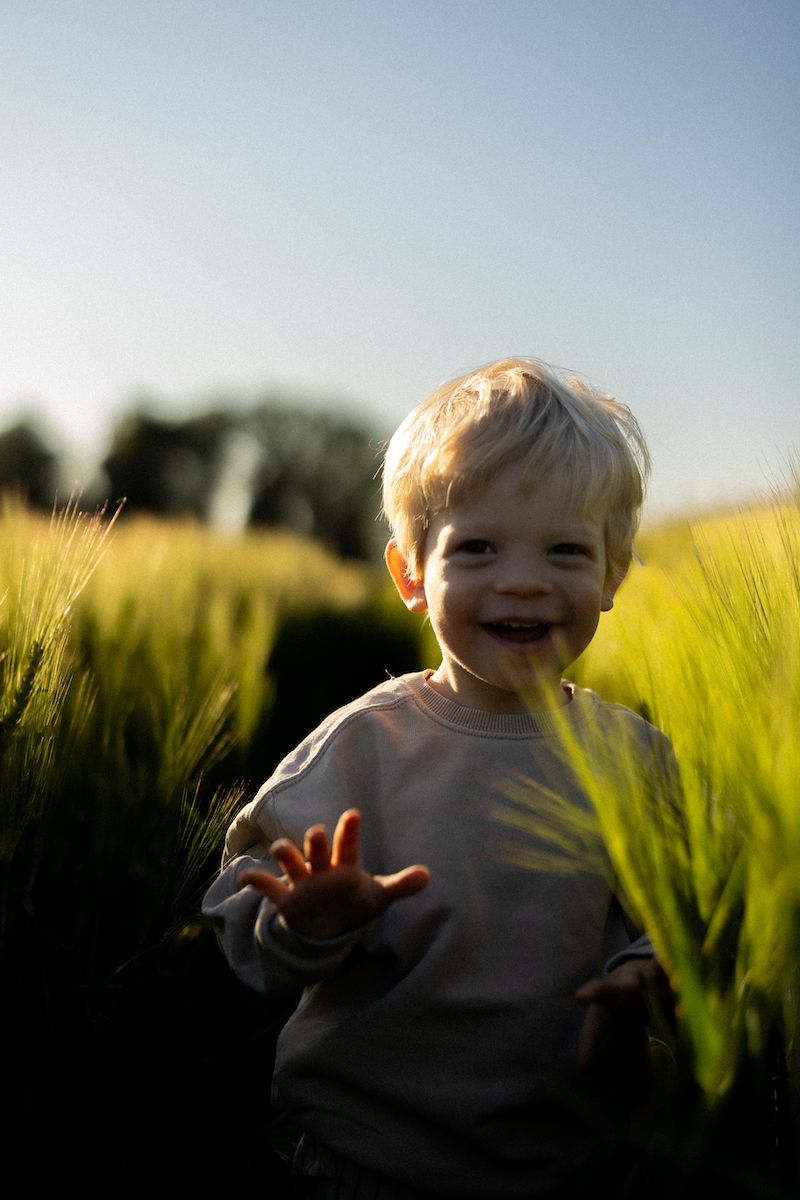 Joyful moment in tall grass field during golden hour.
