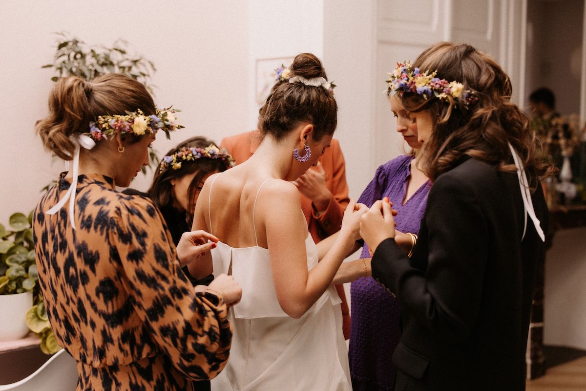 Wedding preparation scene with attendants helping with final touches.
