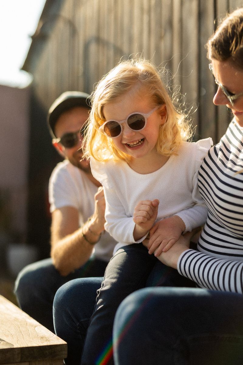 Joyful outdoor gathering with striped shirts and sunglasses in warm sunlight.