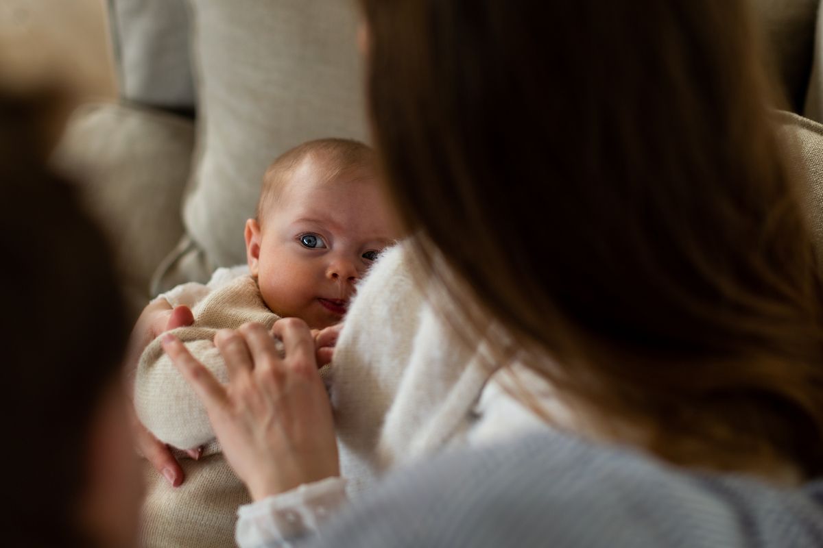 An intimate moment between caregiver and infant shown in warm, natural lighting.