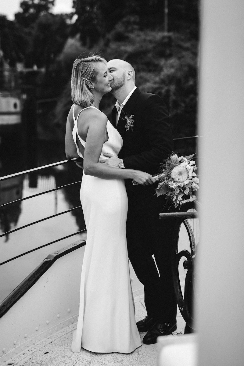 A bride and groom share intimate kisses in a sequence of black and white photos on stairs.