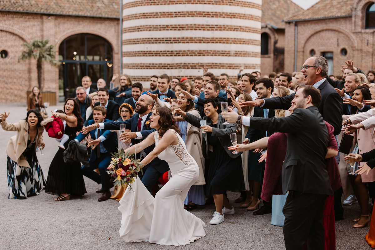 Celebratory dance moves at an outdoor wedding reception with crowd cheering.