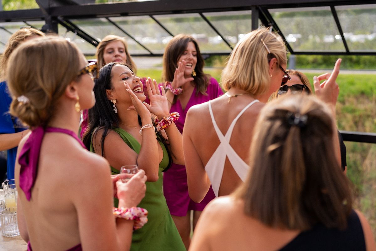 Wedding party enjoying a candid moment outdoors with laughter and celebration.