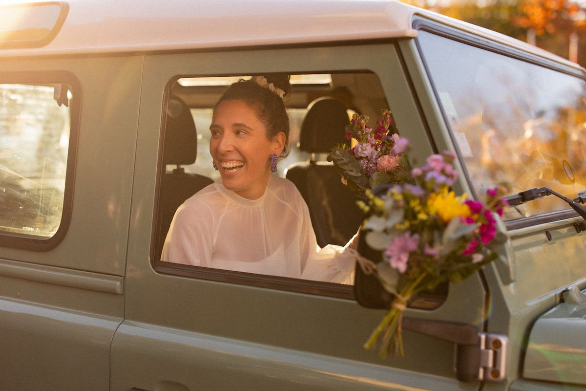 Person in car with flowers during golden hour celebration.