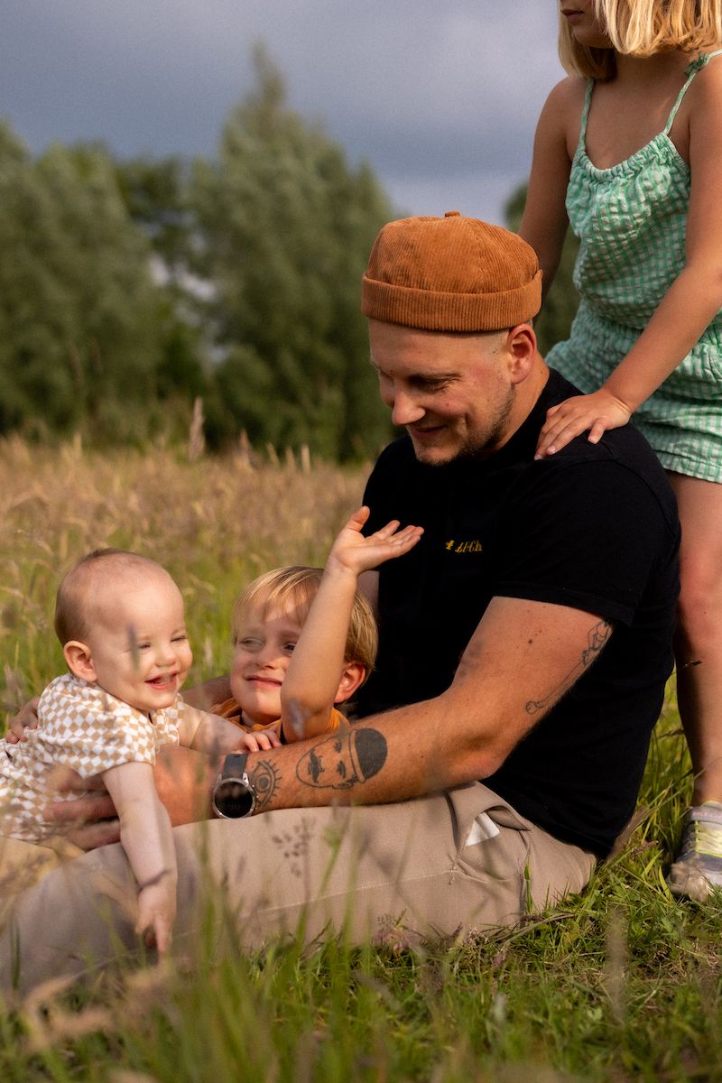 Family spending time together outdoors in tall grass during summer.