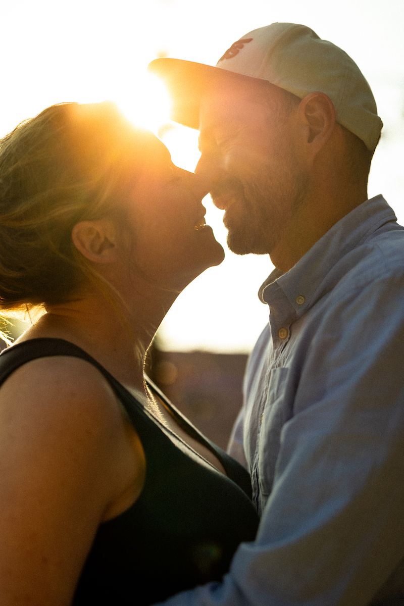 Intimate moment between two people silhouetted against a beautiful sunset.