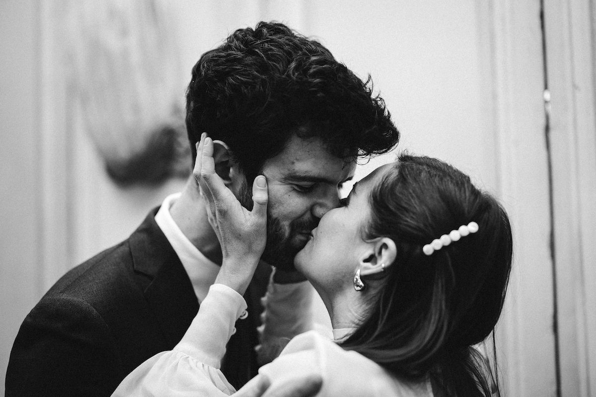 A tender black and white moment between newlyweds sharing an intimate embrace.