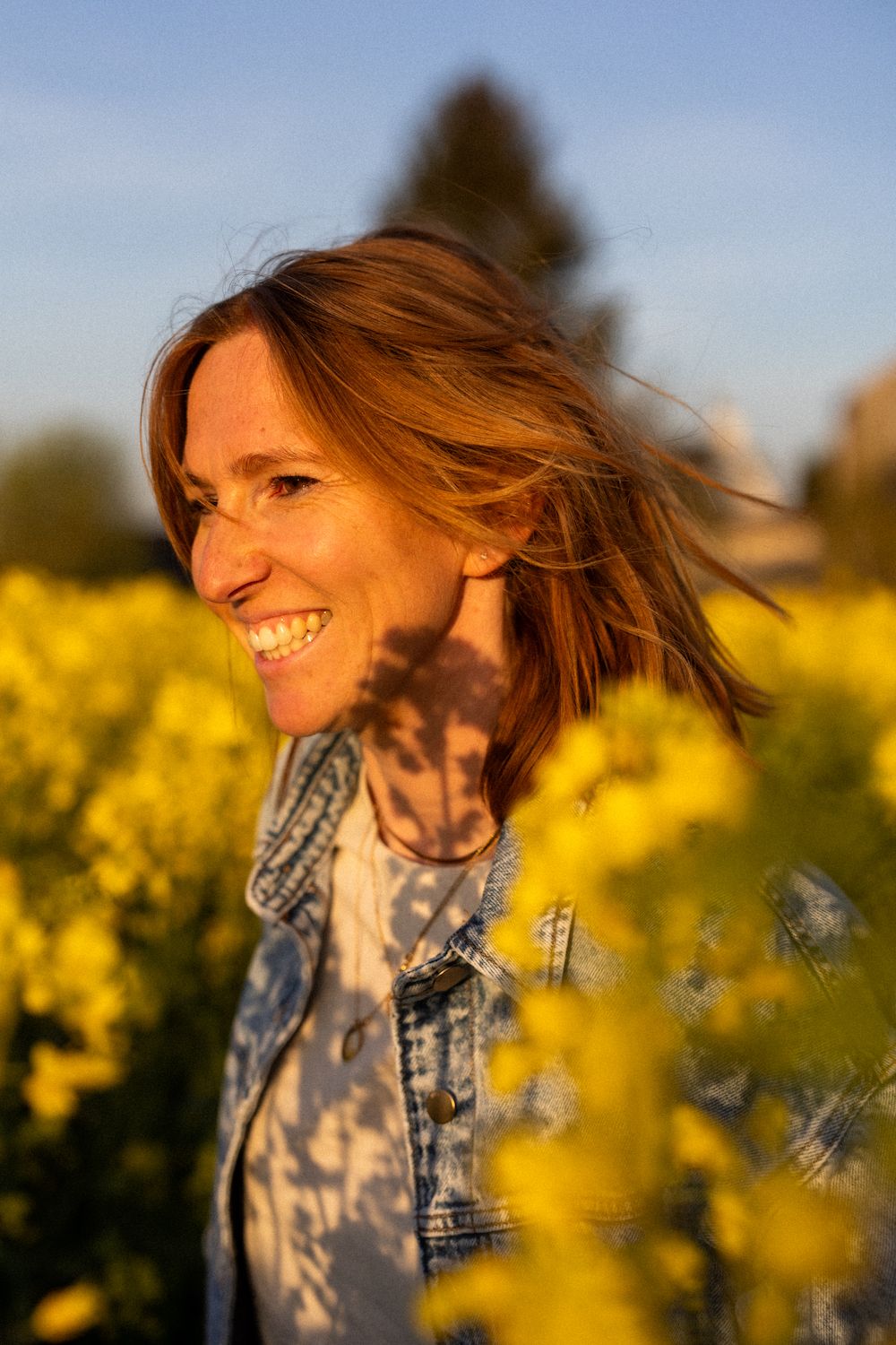 Figure moving through blooming yellow canola field under blue sky.