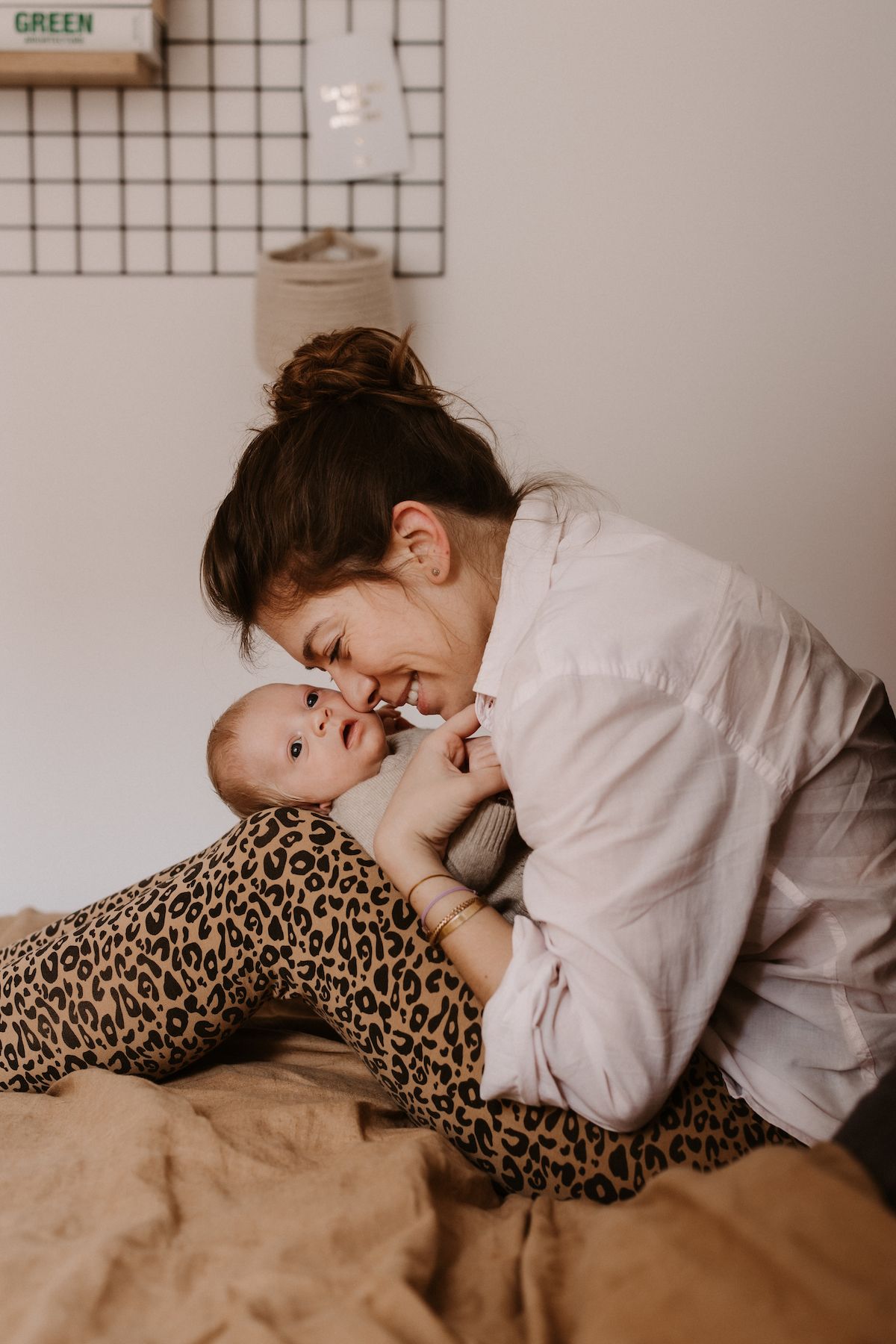 Intimate moment captured on a bed with leopard print accents and soft lighting.