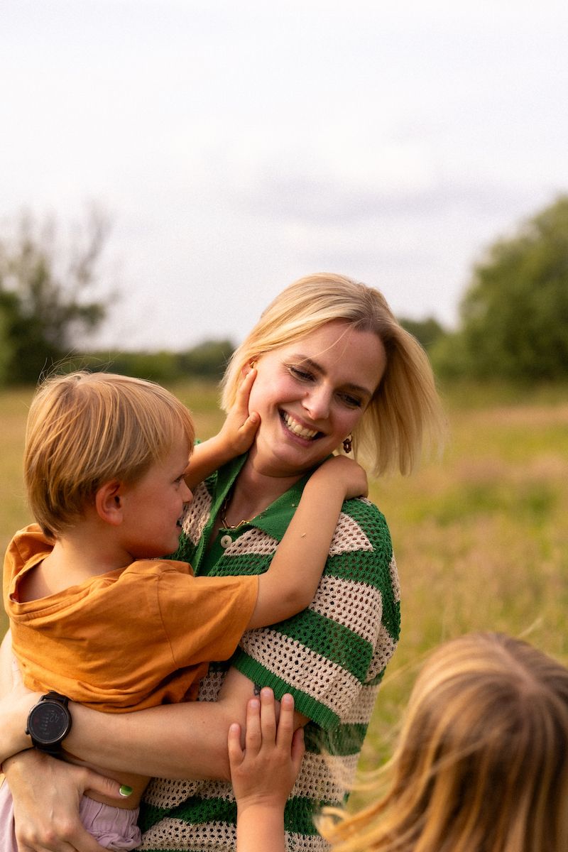 Sweet embrace captured in outdoor setting with green polka dot clothing details.