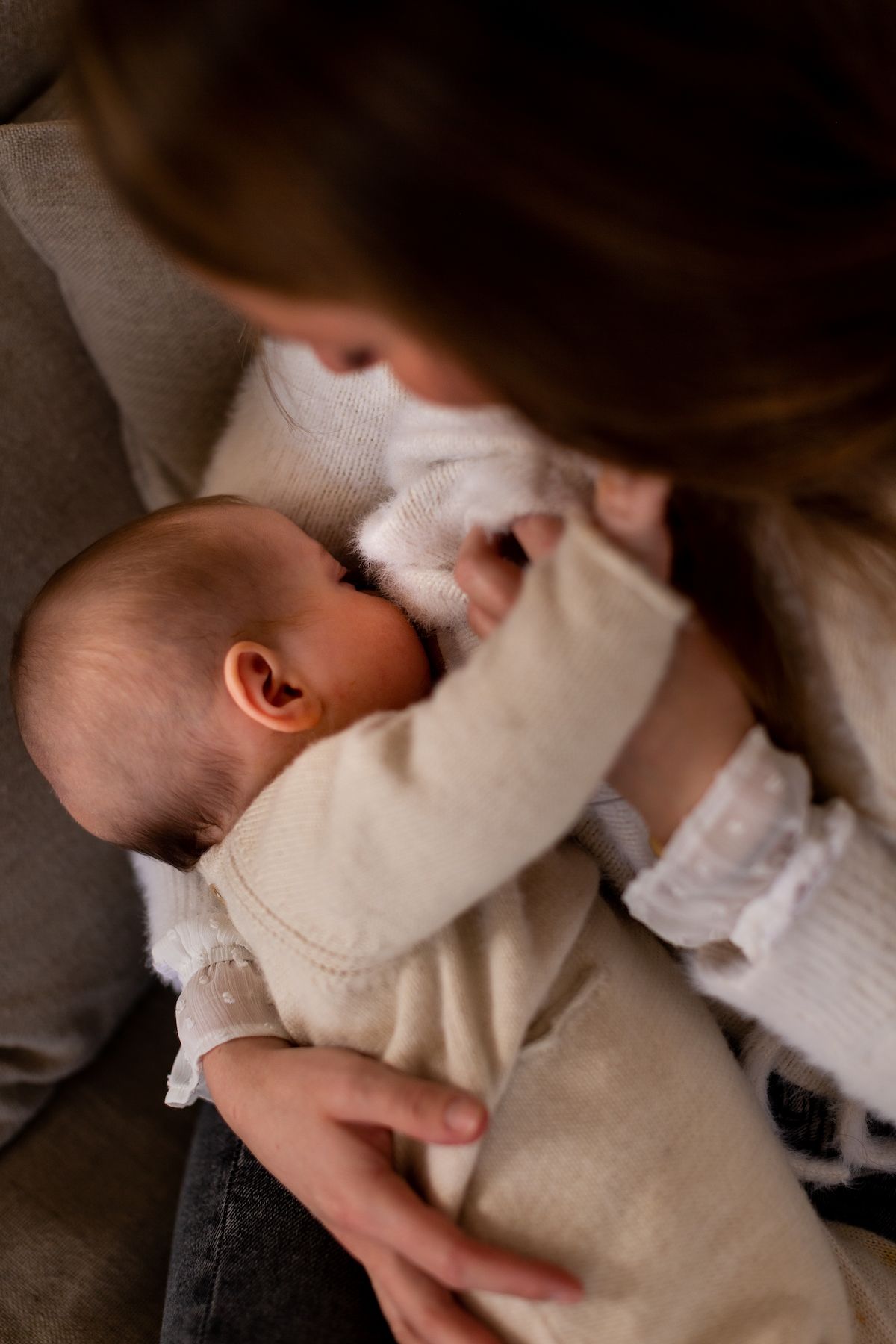 A peaceful moment showing gentle care of a baby wrapped in soft beige fabric.