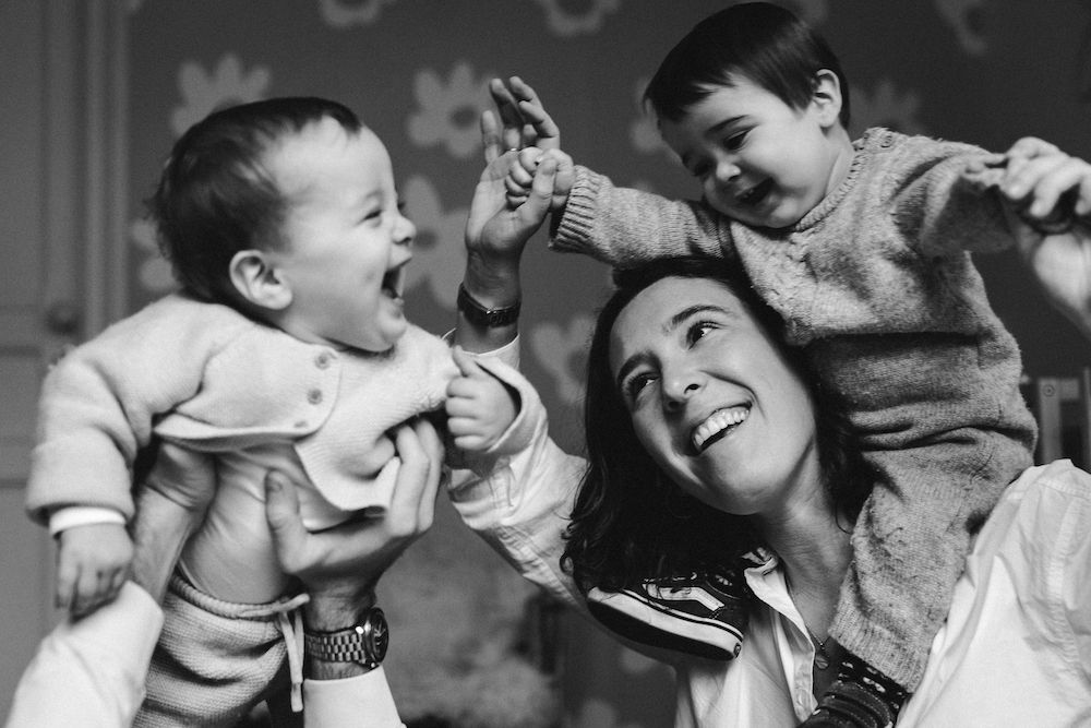 Candid black and white portrait of playful family moments indoors.