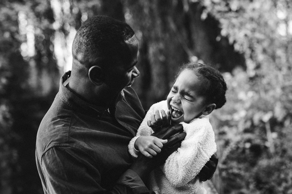 Tender family moment captured in black and white photography outdoors.