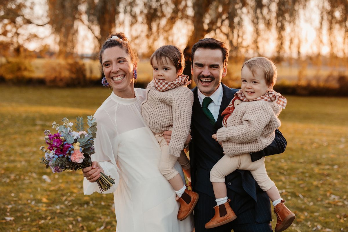 Family portrait in autumn setting with colorful bouquet and warm sunset light.