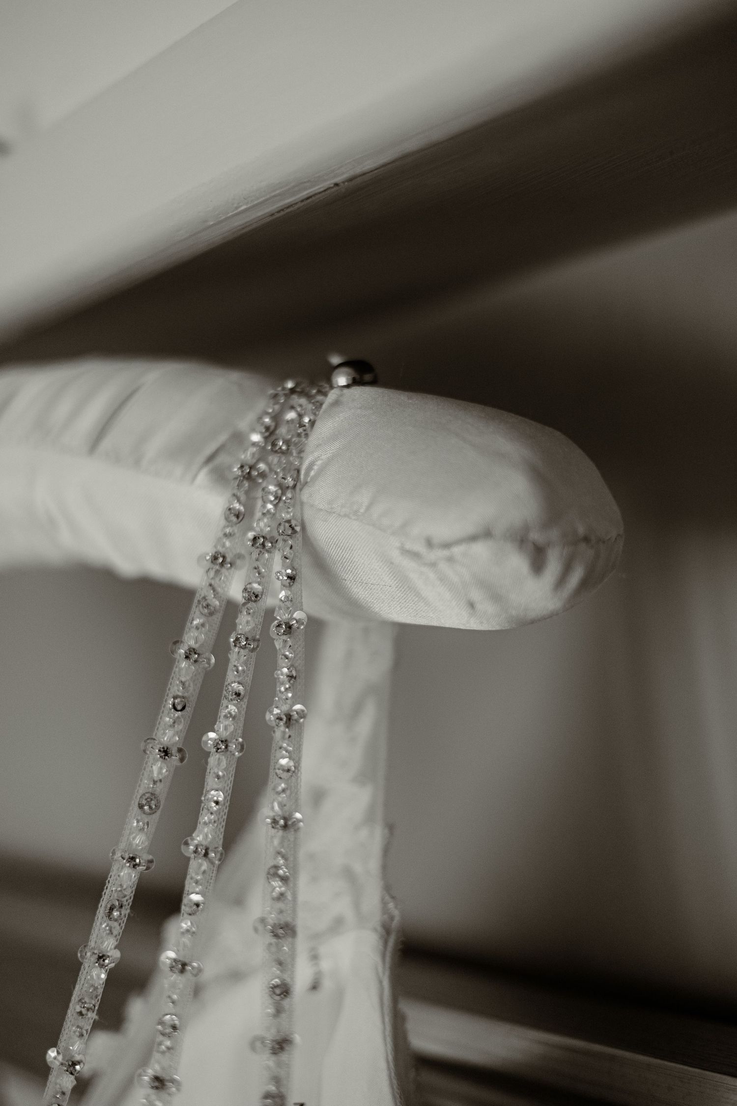 Detailed shot of crystal beaded trim on white wedding dress fabric.