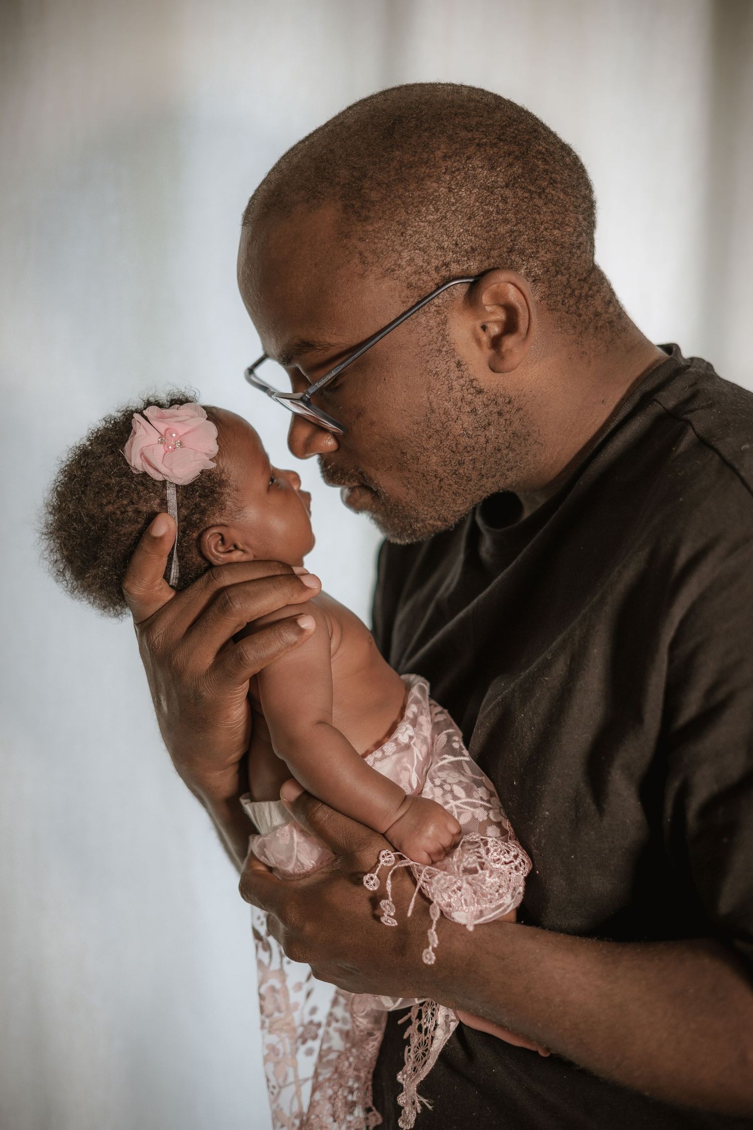 Tender moment between parent and baby in formal black and white close-up photography sequence.