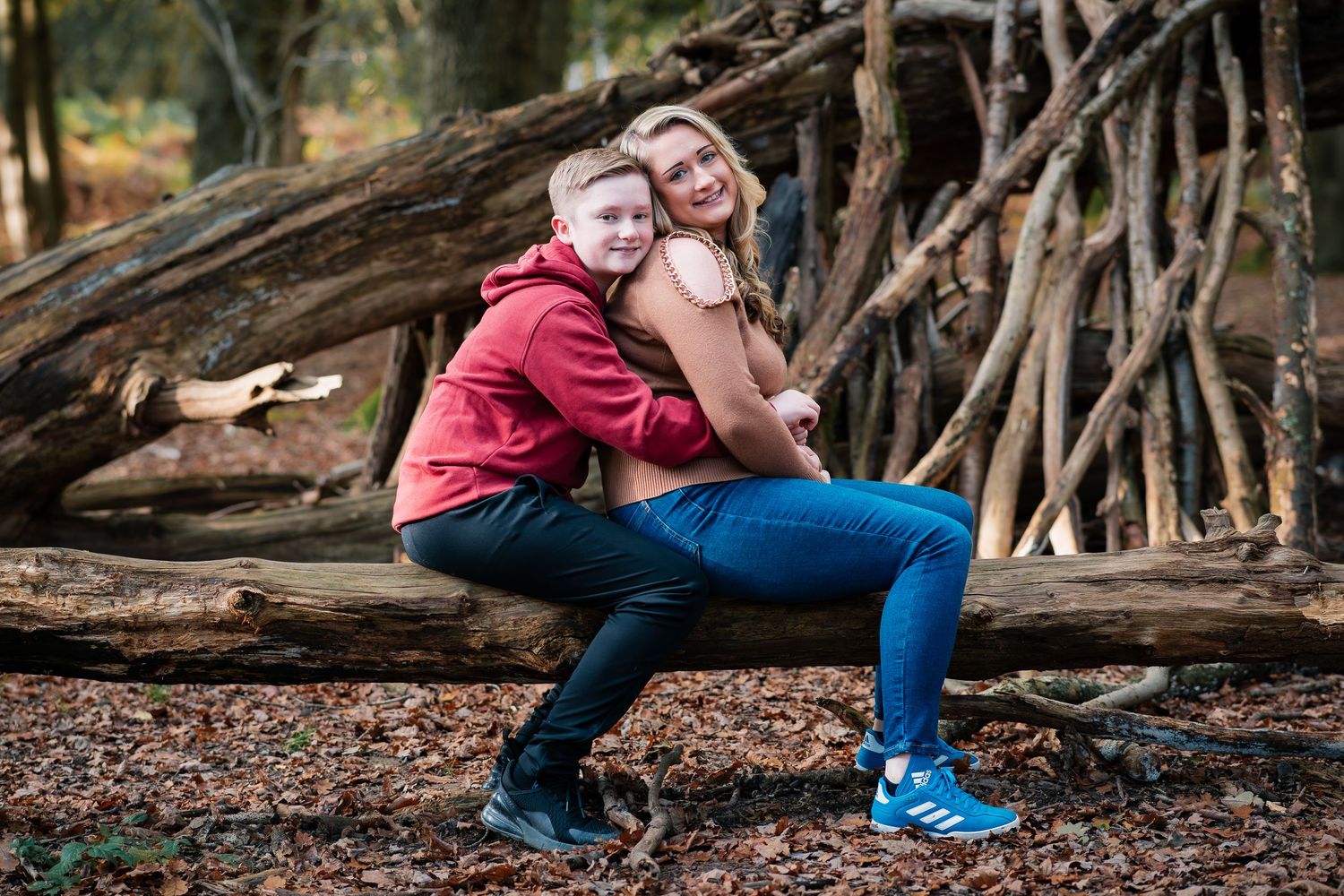 Playful moments captured in a wooded area with natural branch structures.