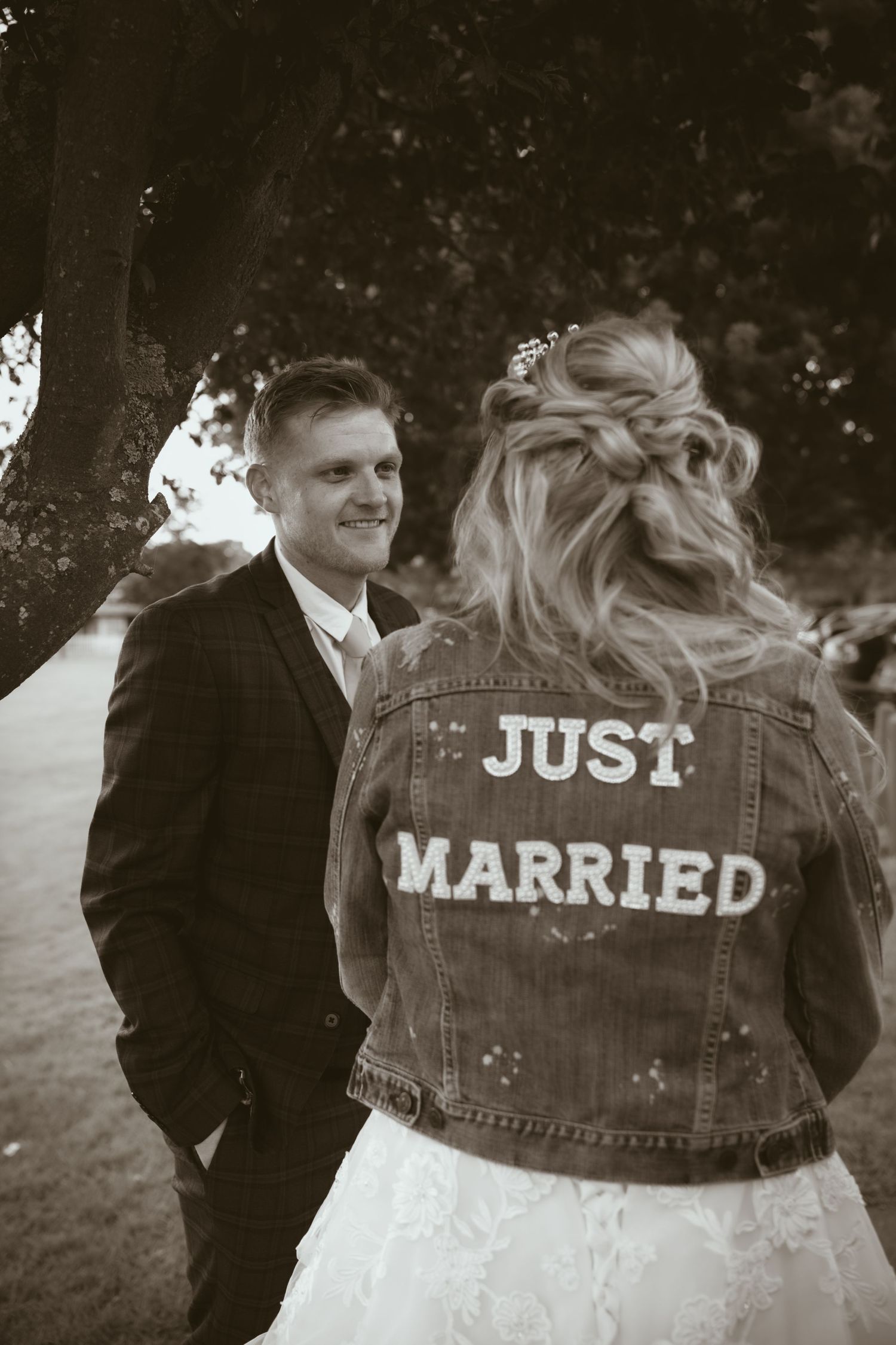 A casual wedding moment featuring denim jacket with 'Just Married' text in black and white.