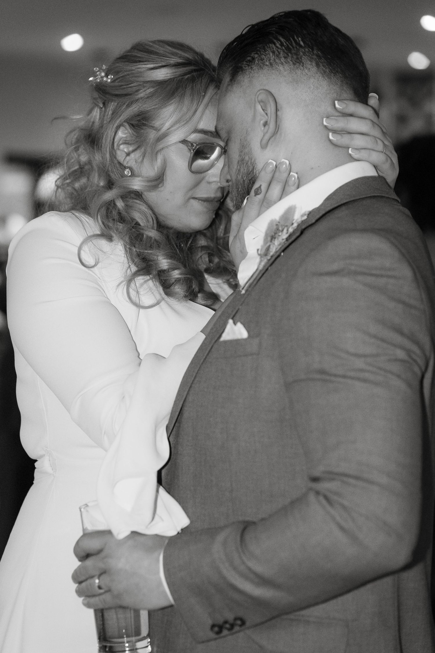 Intimate black and white portrait of newlyweds sharing a tender moment.
