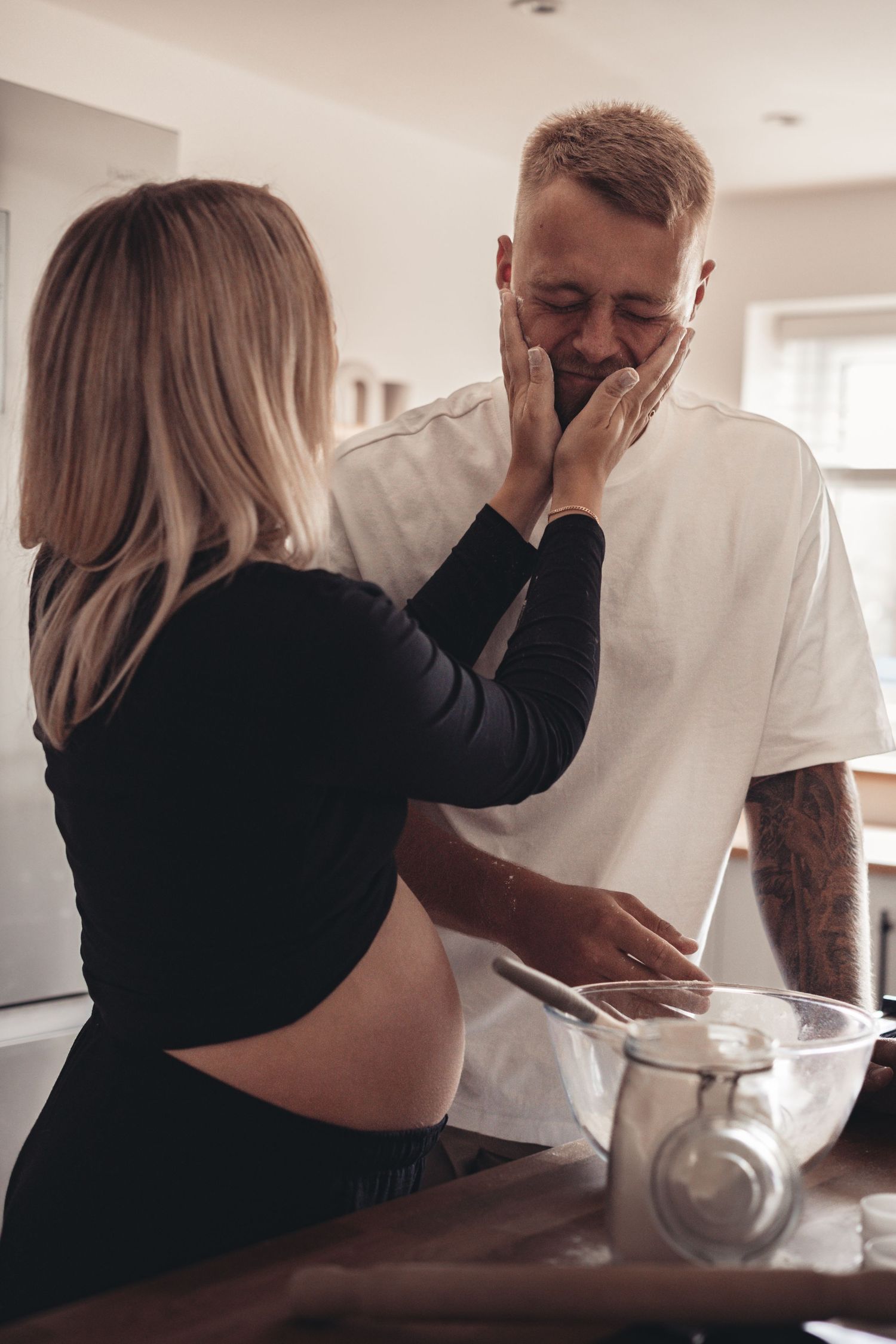 Emotional pregnancy reveal moment in modern kitchen setting.