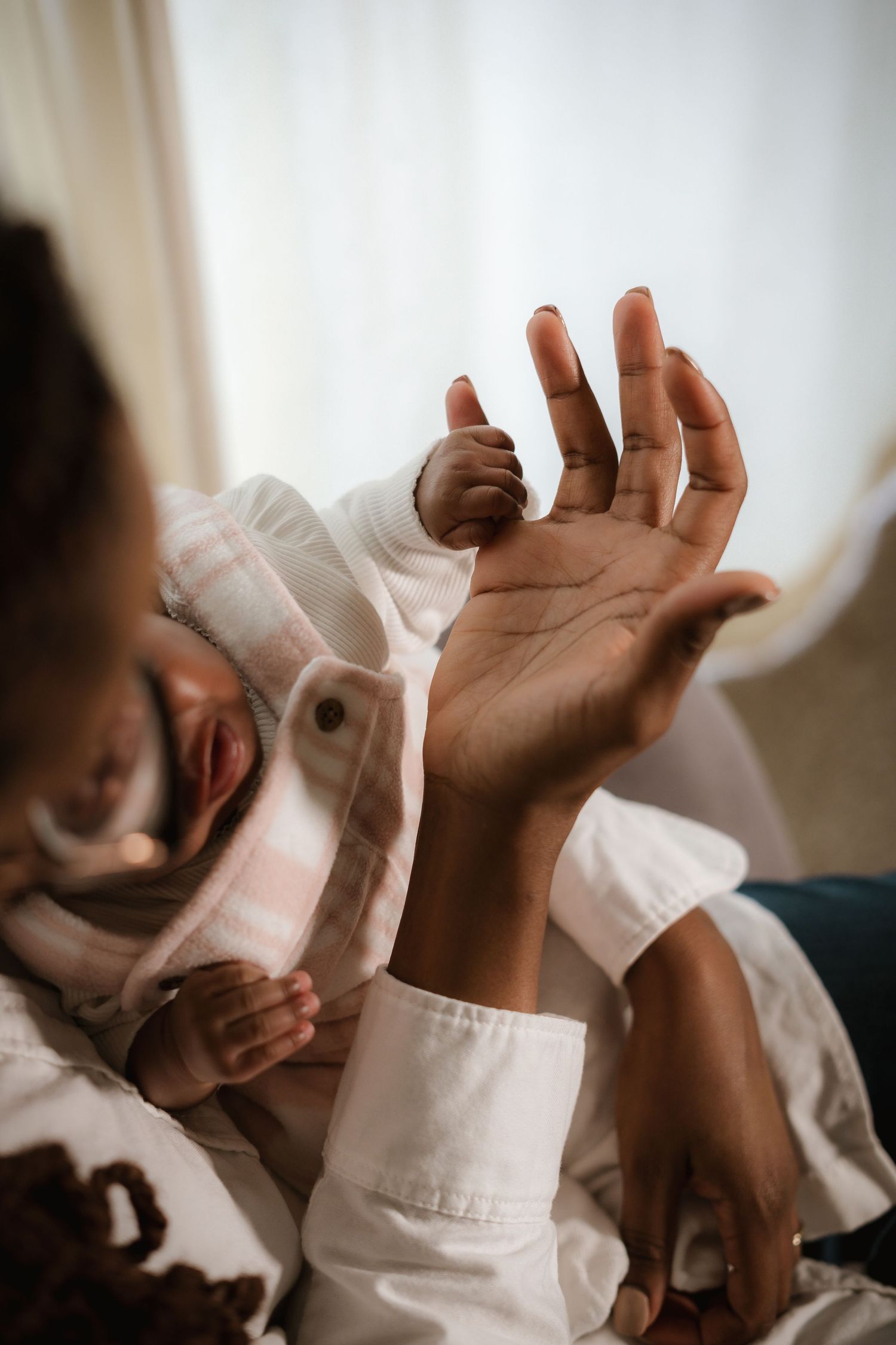 Artistic capture of reaching hands during intimate family moment.