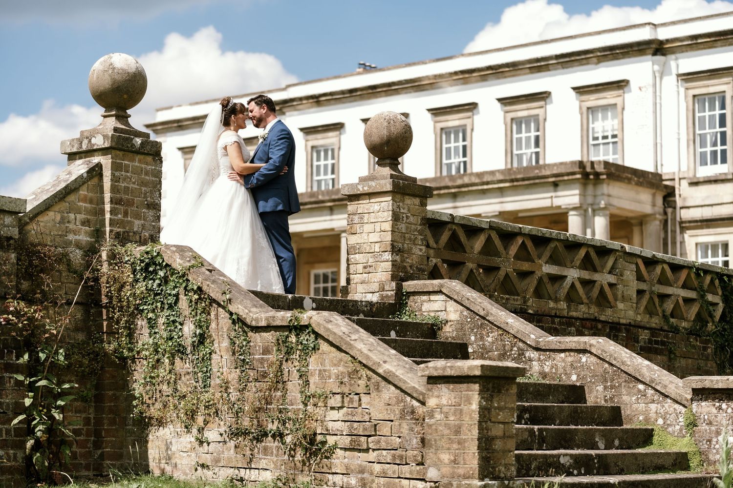Wedding ceremony at a historic stone mansion with grand exterior staircase.