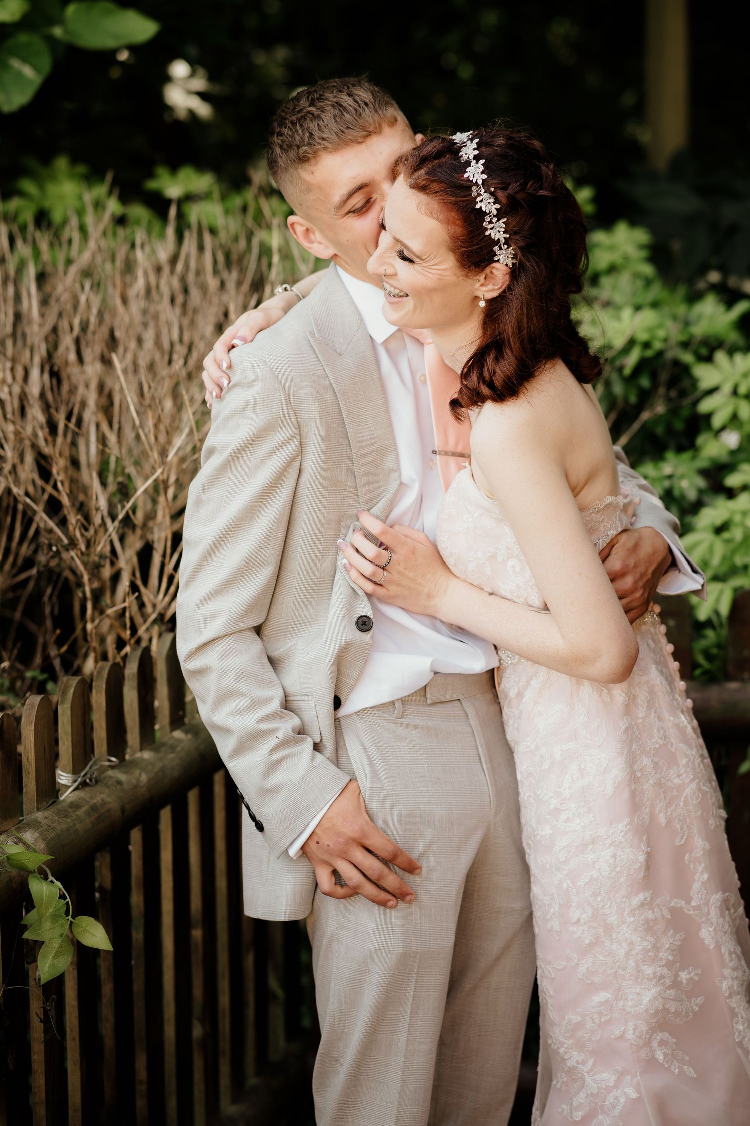A romantic wedding portrait of a couple in light-colored attire.