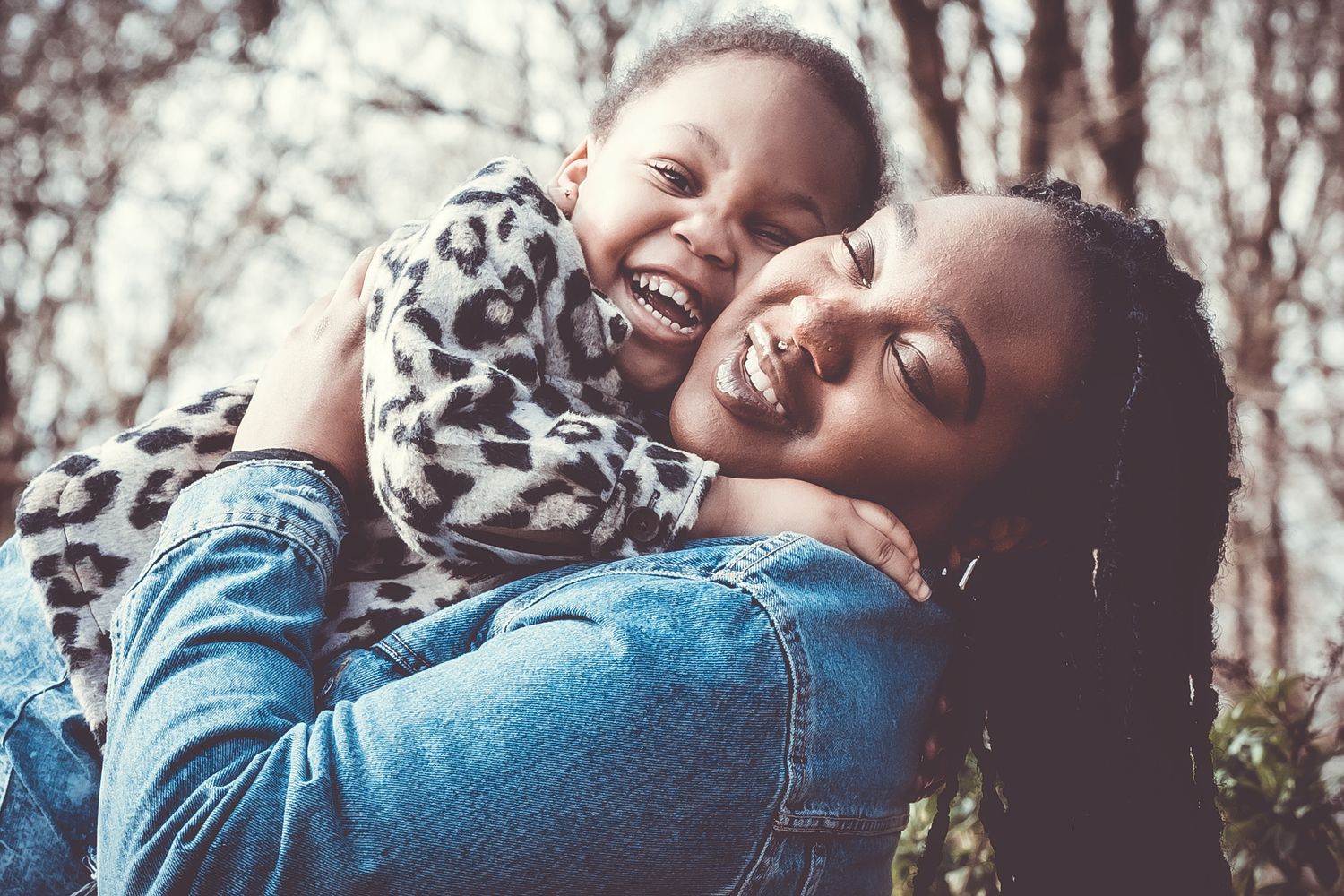 Joyful moment captured between two people laughing and embracing outdoors.