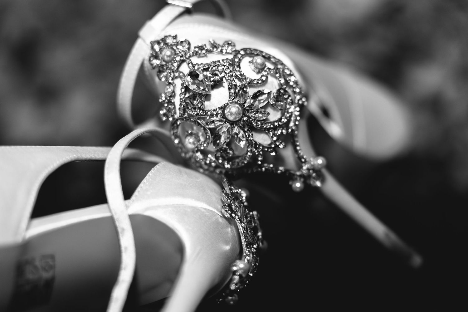 Black and white macro shot of sparkling wedding jewelry details.