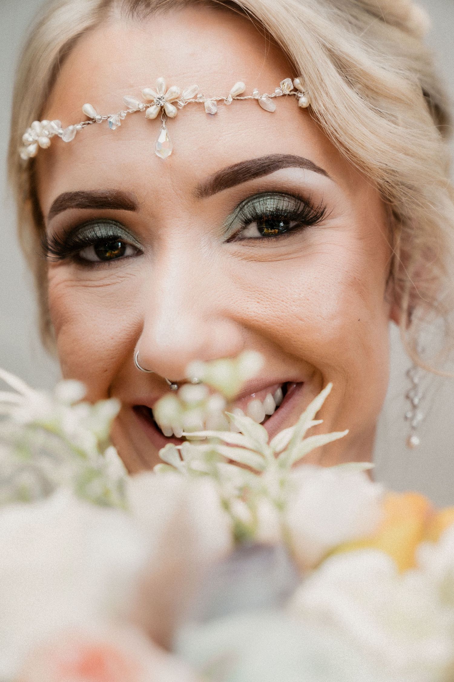 Delicate pearl headpiece adorns updo hairstyle with natural makeup.