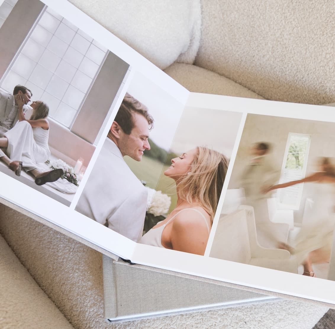 Wedding photo album with white pages laid open displaying professional photographs.
