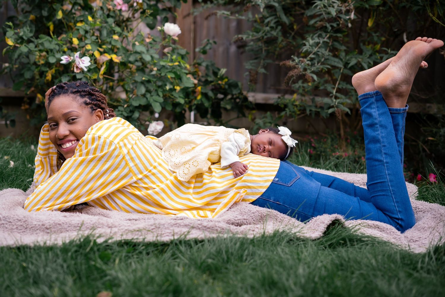 Joyful moment of relaxation on grass during an outdoor family photoshoot.