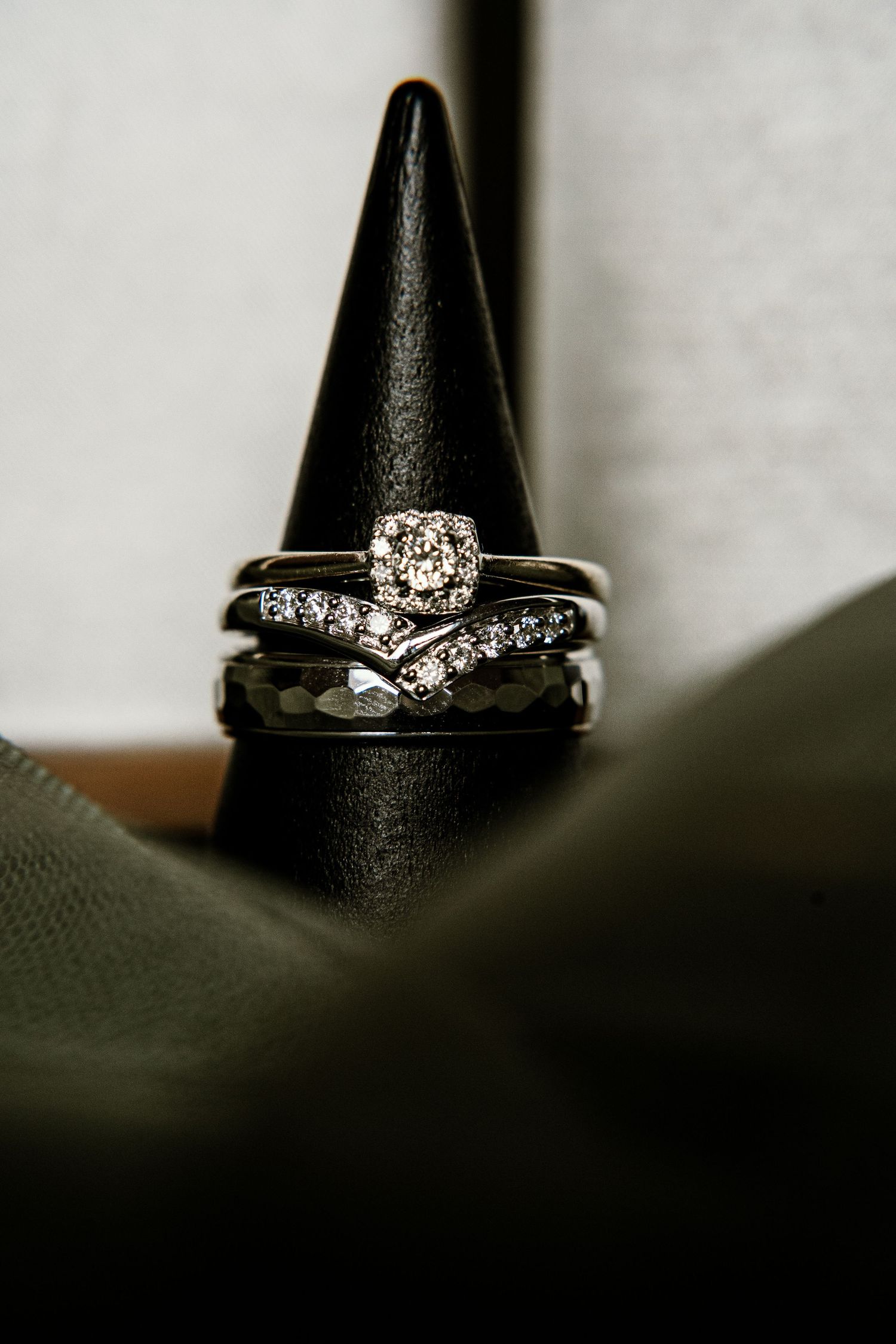 Elegant diamond engagement ring and wedding band set displayed on black cone holder.