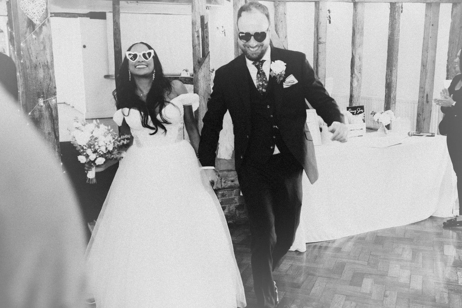 A black and white wedding photo showing dancing and celebrations at an elegant reception.