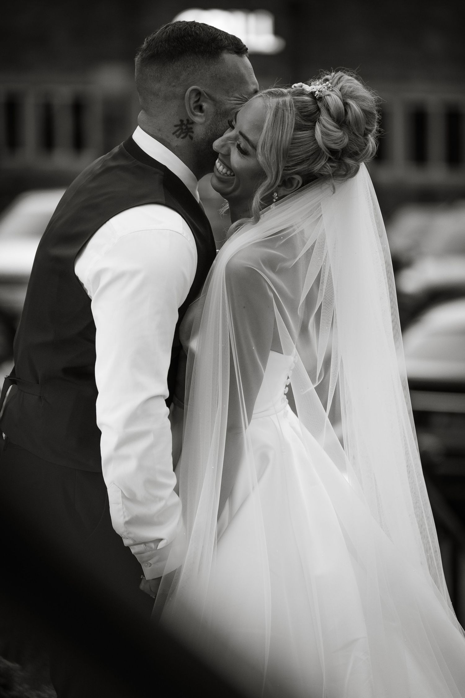 Intimate black and white portrait of newlyweds sharing a tender moment.