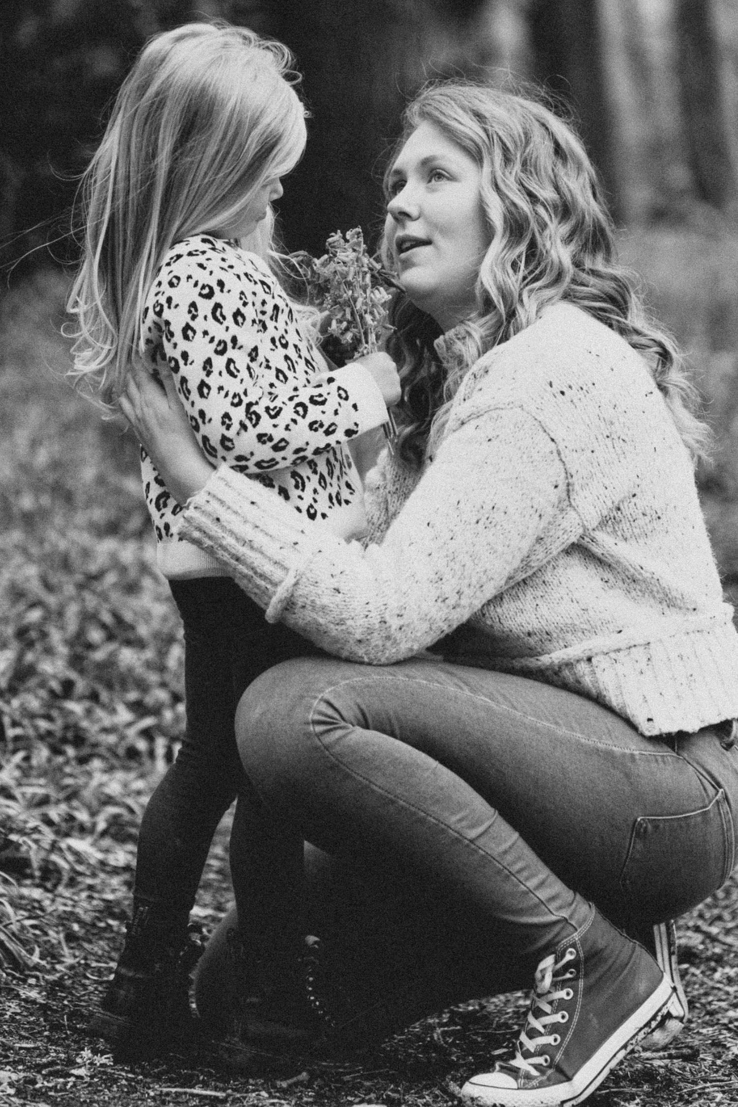 Black and white photography capturing intimate moments among spring flowers.