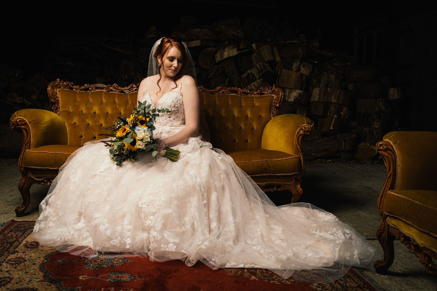 A wedding dress portrait on an antique gold velvet sofa with floral bouquet.