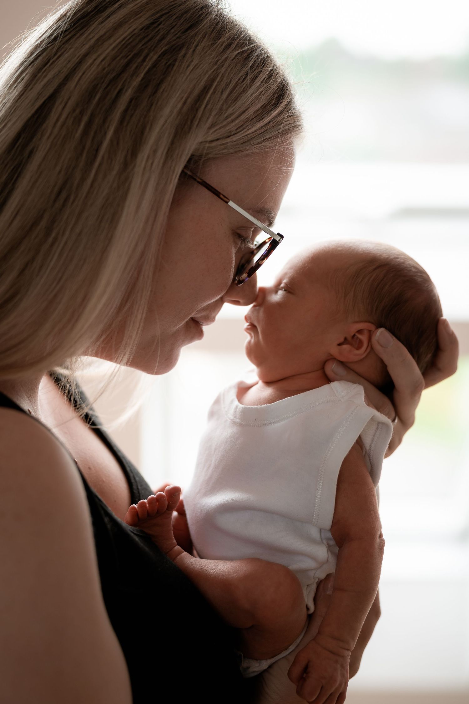 An intimate moment between a newborn baby and caregiver in a softly lit room.