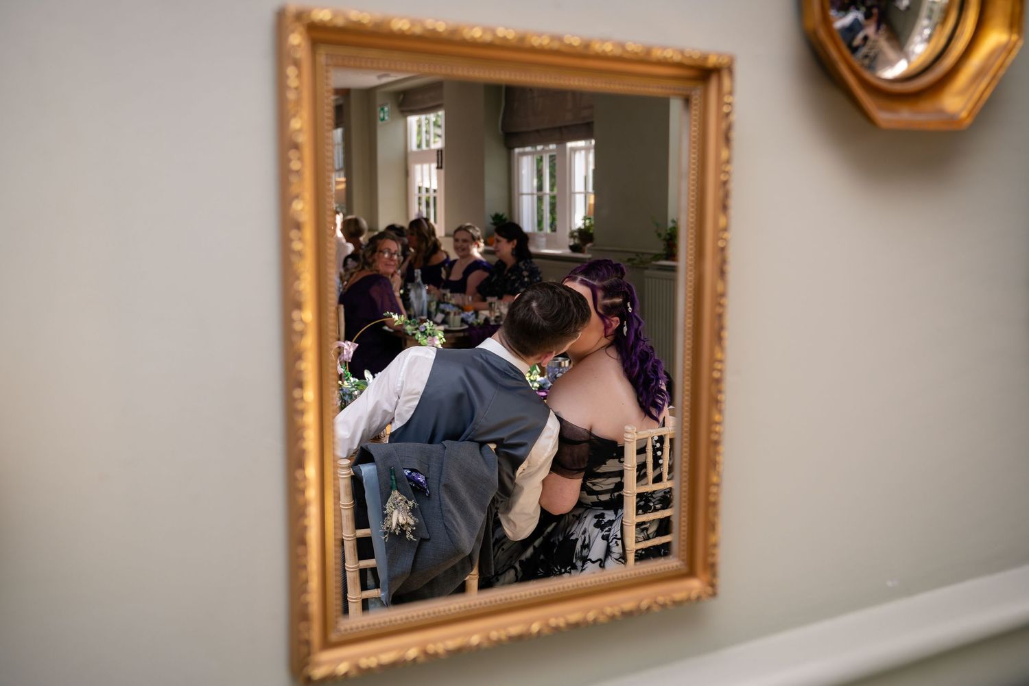 Ornate gold-framed mirrors reflect a wedding day scene on light gray walls.