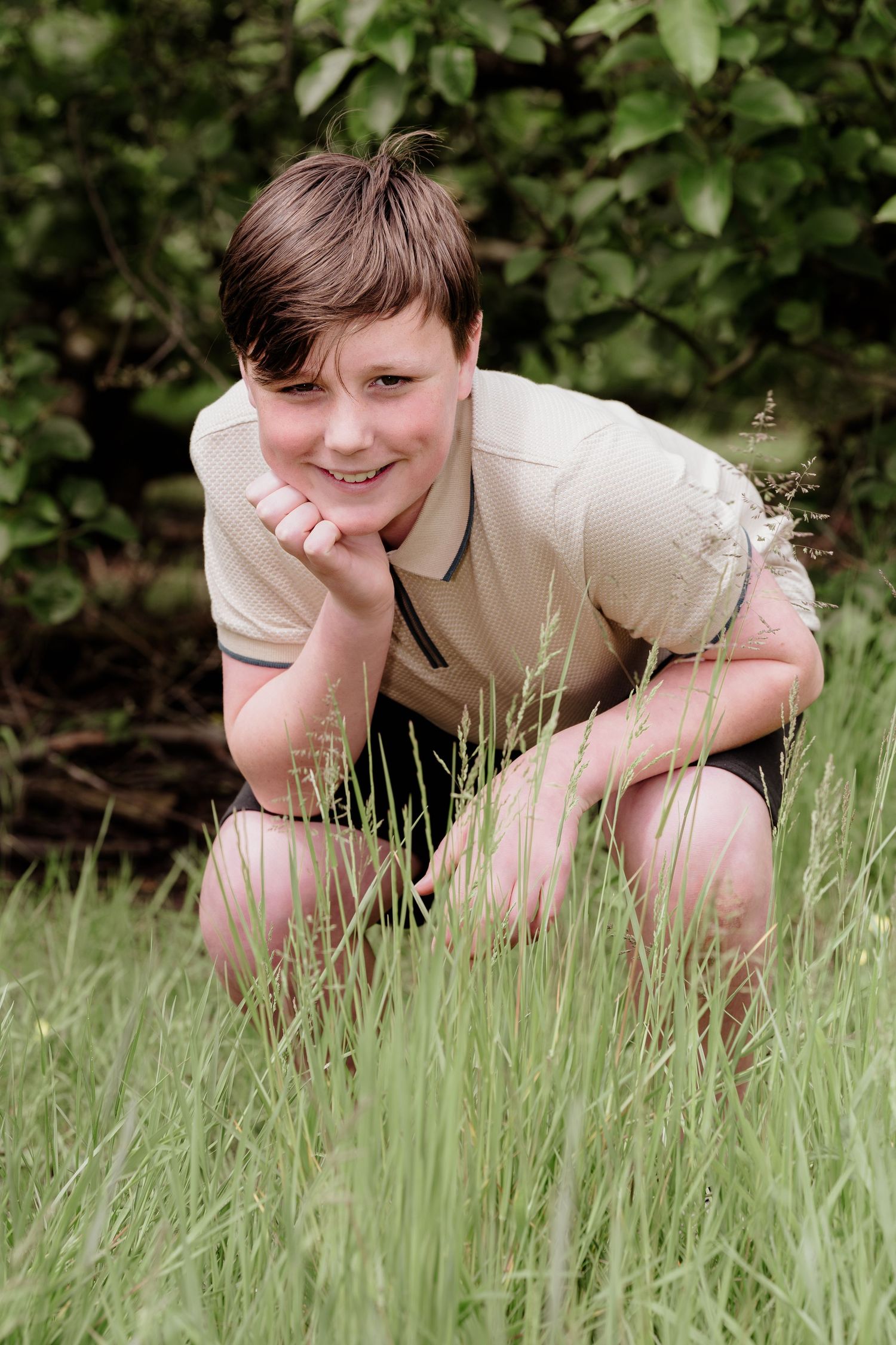 Person relaxes in tall grass on a sunny day wearing a light colored shirt.