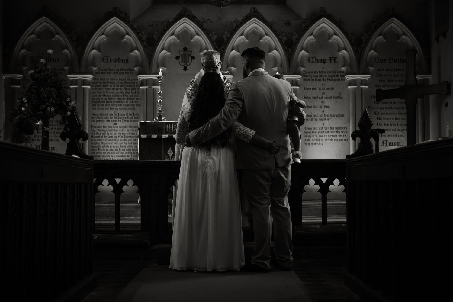 Silhouetted couple standing in church aisle with dramatic Gothic architecture in background.
