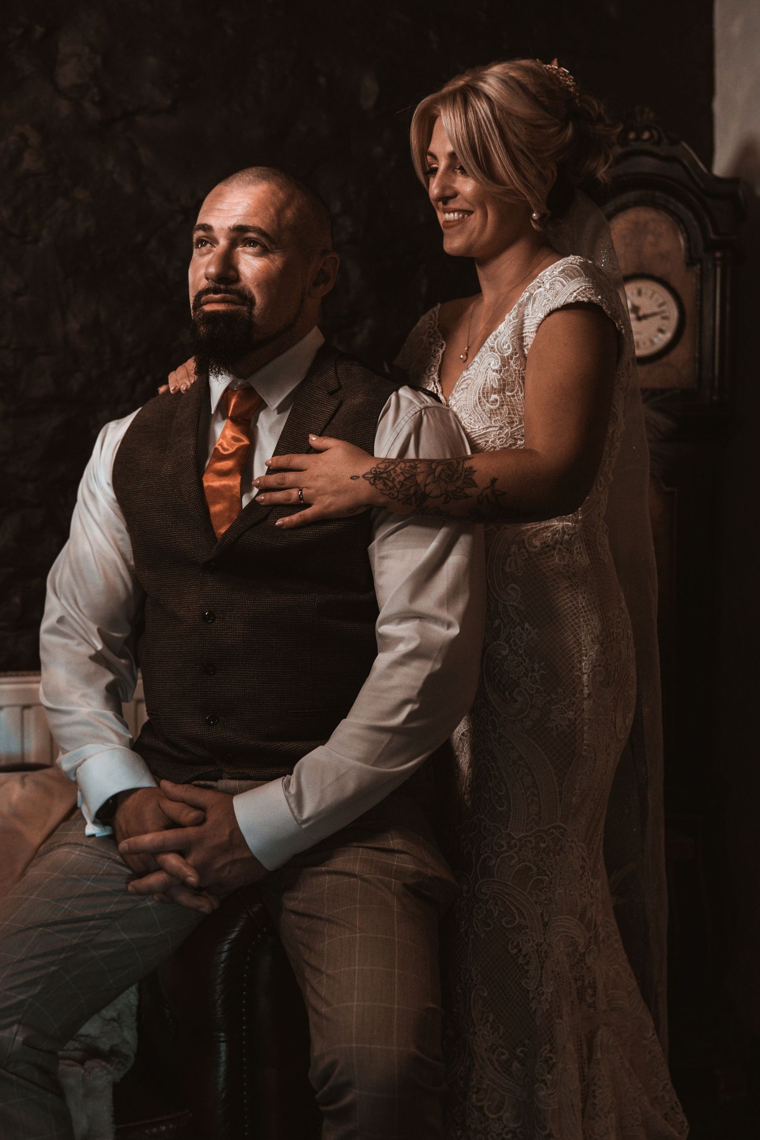 Intimate wedding portrait in moody lighting with vintage decor.
