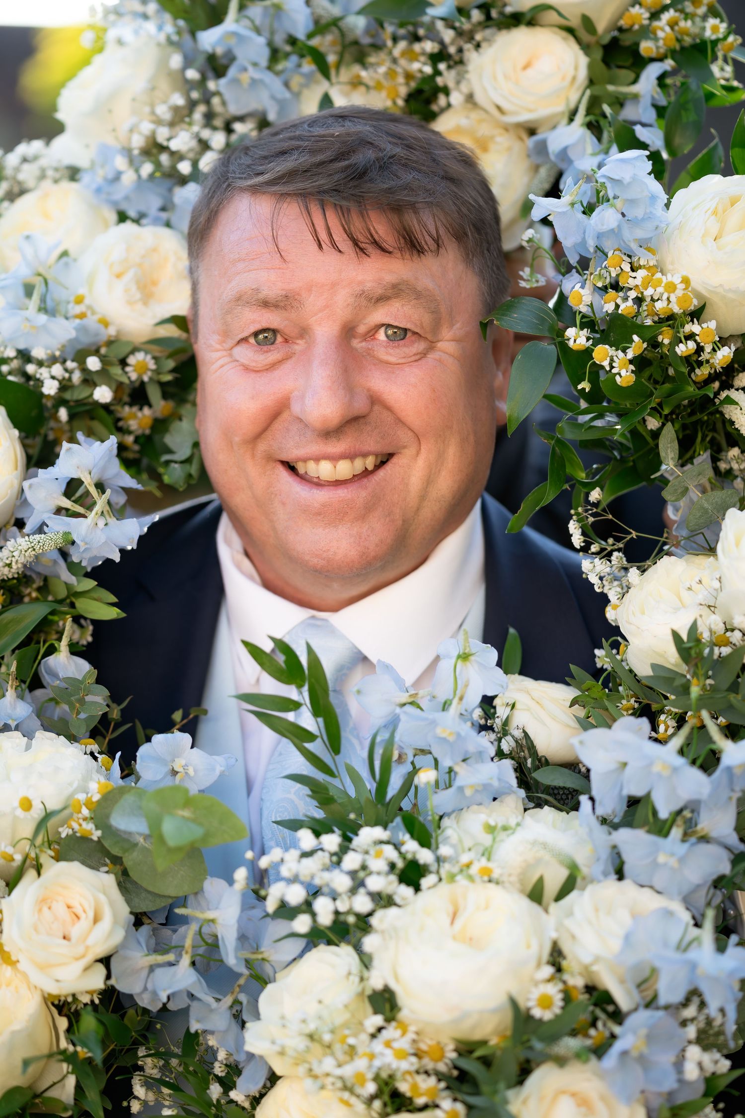 A portrait surrounded by elegant white roses and baby's breath floral arrangements.