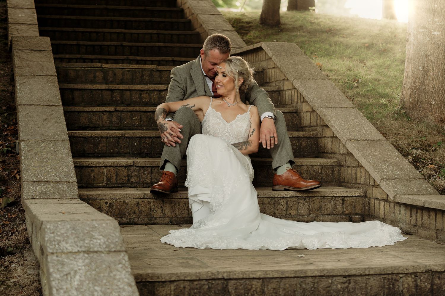 Romantic pose on stone steps at sunset with flowing wedding dress.
